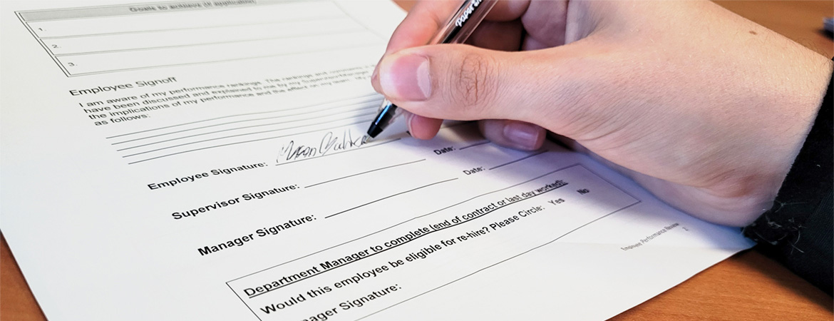 Photo of a person signing a document