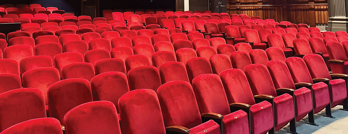 Red seats in an empty theatre.