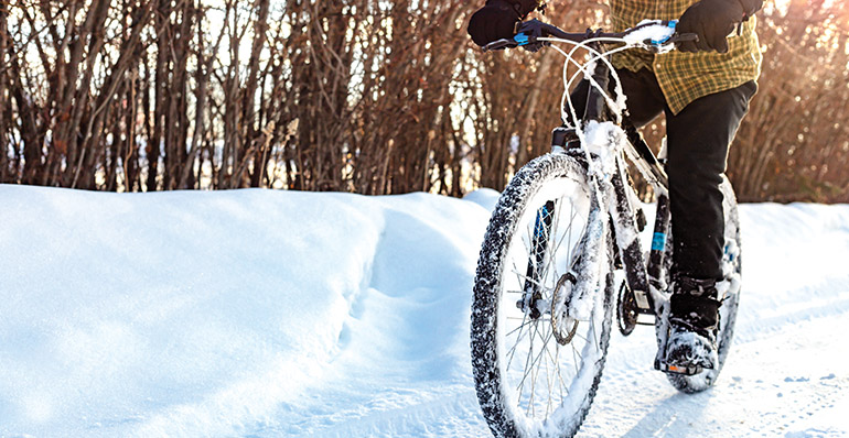 A bike being ridden through the snow.