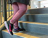 A photo of a person in running shoes walking up a set of stairs.