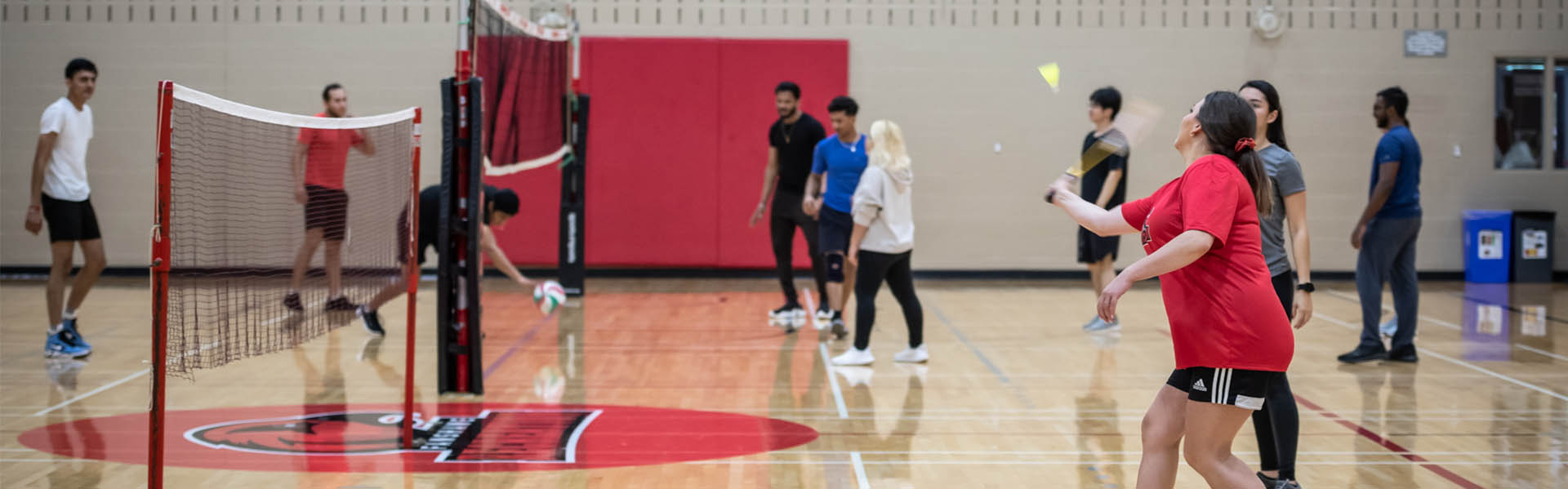 Photo of students play volleyball inside a gym