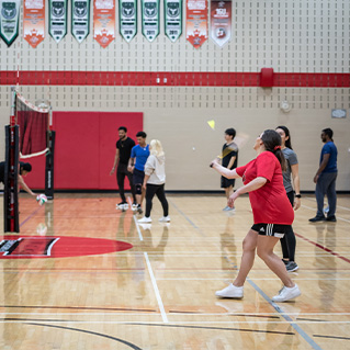Photo of students play volleyball inside a gym